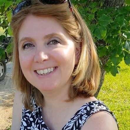 Blonde lady smiling near a tree